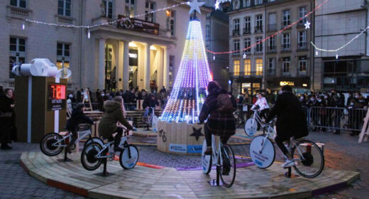 Flocon de neige lumineux sur la Place Gutenberg à Strasbourg, éclairé grâce à l'énergie produite par des vélos générateurs lors du marché de Noël.