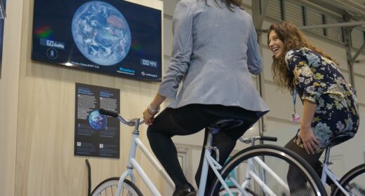 Participants pédalant sur des vélos générateurs pour alimenter un écran diffusant un jeu vidéo, illustrant l'animation interactive de Ludik Énergie.