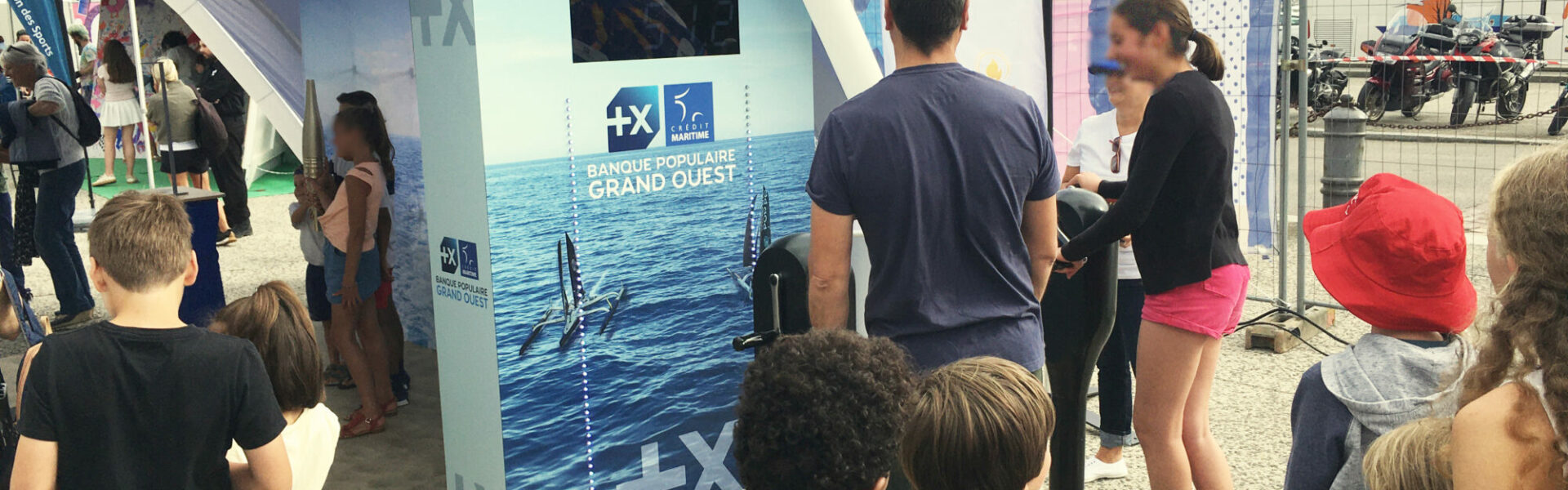 Participants engagés dans l'animation Défi Winch de Ludik Énergie, pédalant sur des vélos générateurs pour activer des lumières LED et simuler le fonctionnement des winchs de bateau