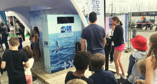 Participants engagés dans l'animation Défi Winch de Ludik Énergie, pédalant sur des vélos générateurs pour activer des lumières LED et simuler le fonctionnement des winchs de bateau