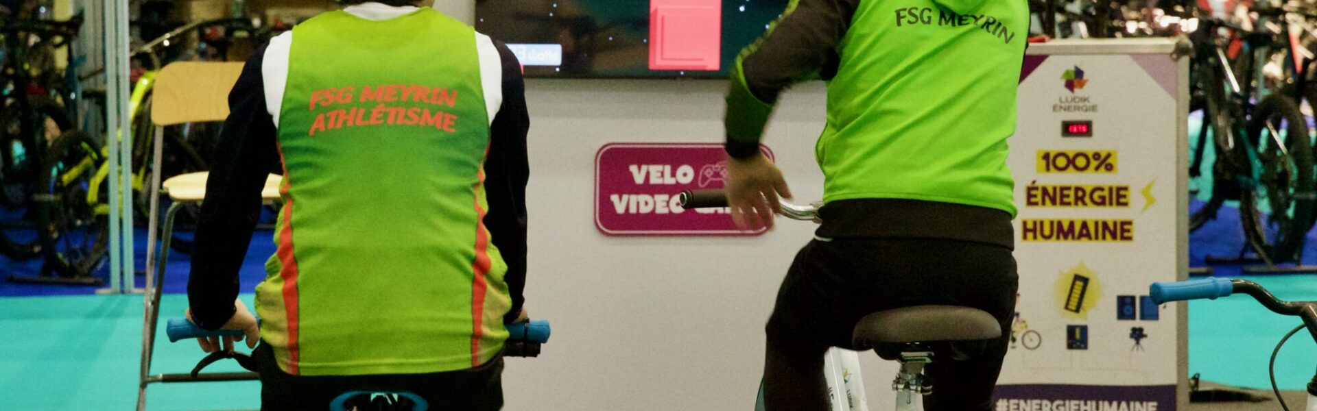 Animation Vélo Jeu Vidéo de Ludik Énergie en extérieur, où des participants pédalent pour alimenter un écran géant diffusant un jeu vidéo