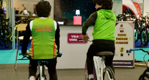 Animation Vélo Jeu Vidéo de Ludik Énergie en extérieur, où des participants pédalent pour alimenter un écran géant diffusant un jeu vidéo
