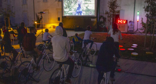 Montage du dispositif Vélo Cinéma de Ludik Énergie, montrant des vélos générateurs connectés à un écran gonflable et à un système de sonorisation en plein air.